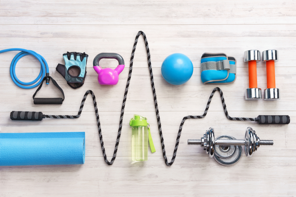 Various pieces of exercise equipment with jump rope in the middle symbolizing a heartbeat