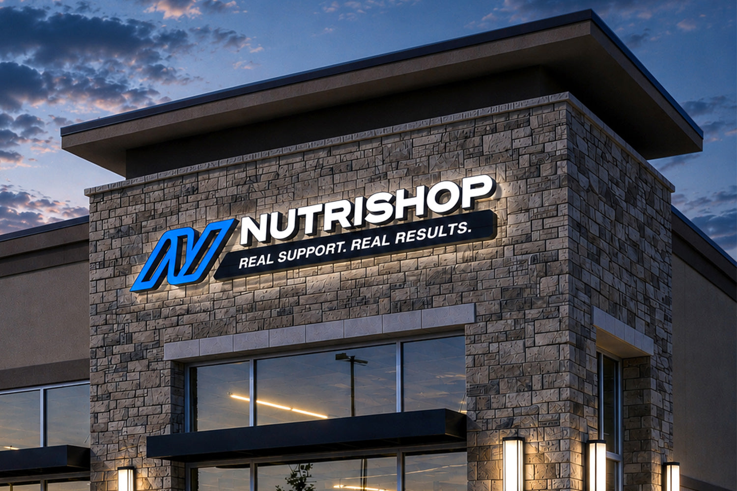 Photo of Nutrishop store location at dusk with the signage lit up